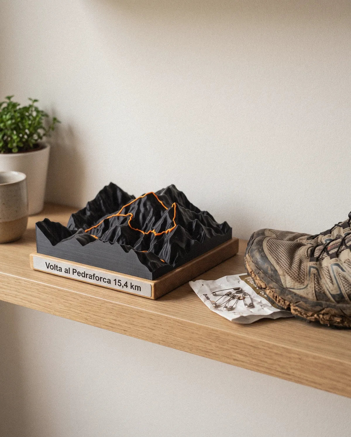 Relleu 15×15 en una estantería, junto a unas zapatillas de trail