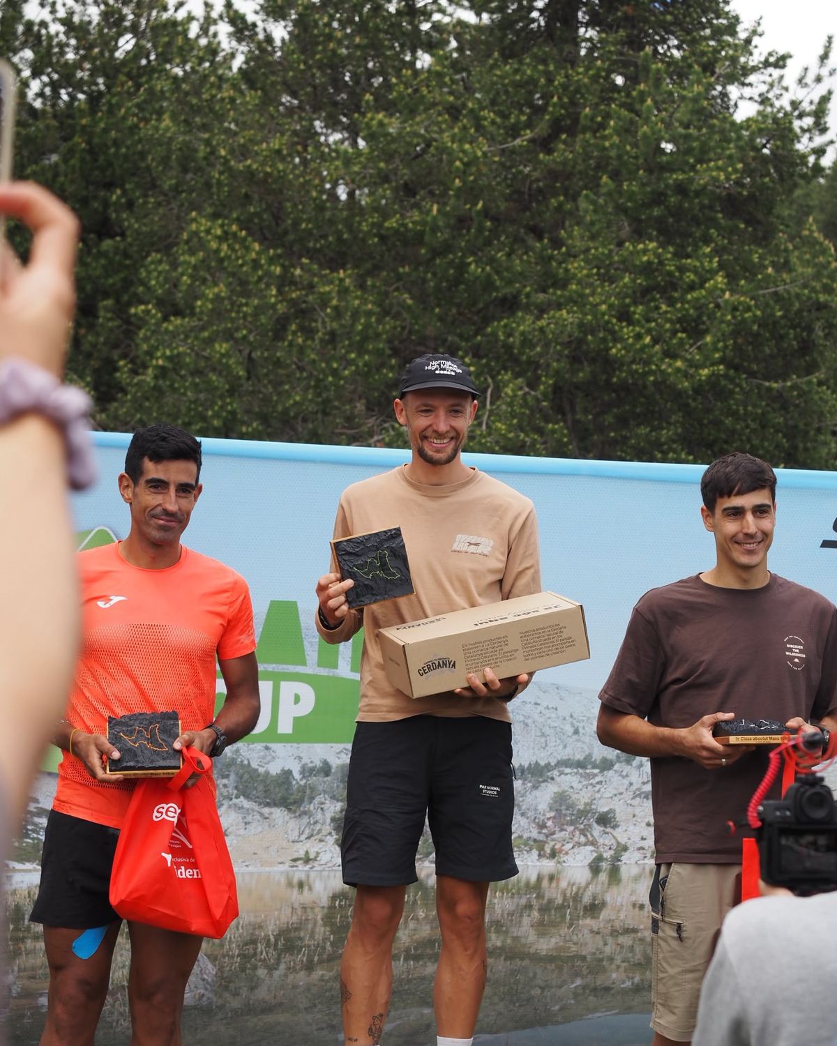 Podio de Les X Trail con los trofeos
